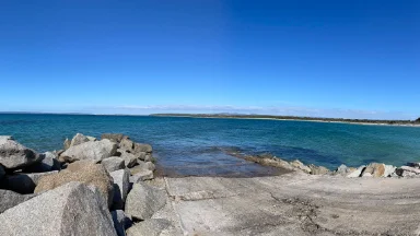 Rocks down the side of a concrete boatramp into the water
